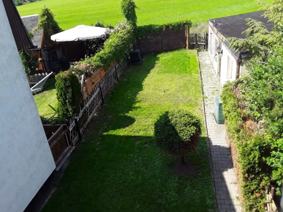 Gepflegter Garten mit gemähtem Rasen und geschnittener Hecke nach dem Einsatz